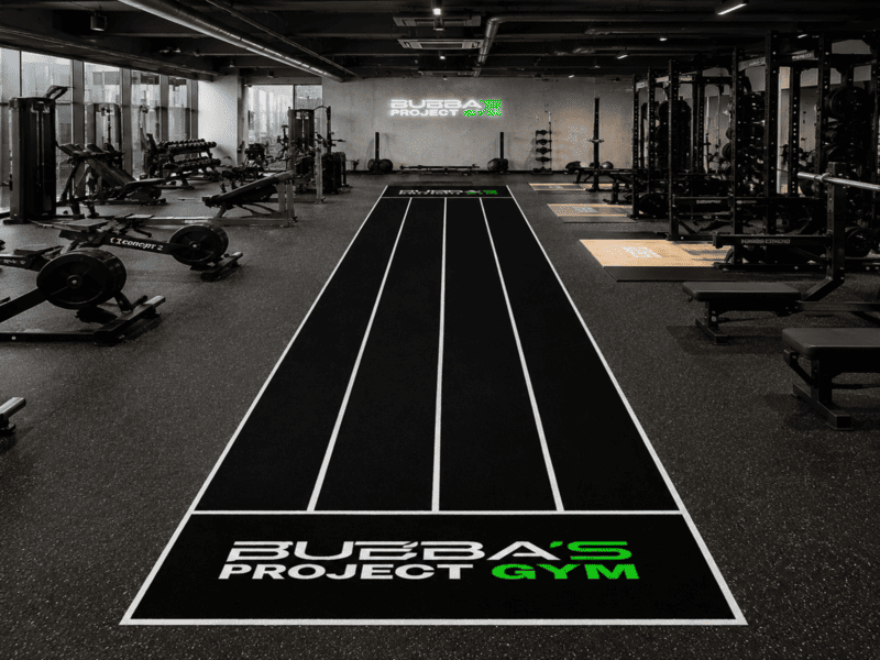Atleta realizando un fuerte empuje de trineo sobre césped verde Hyrox